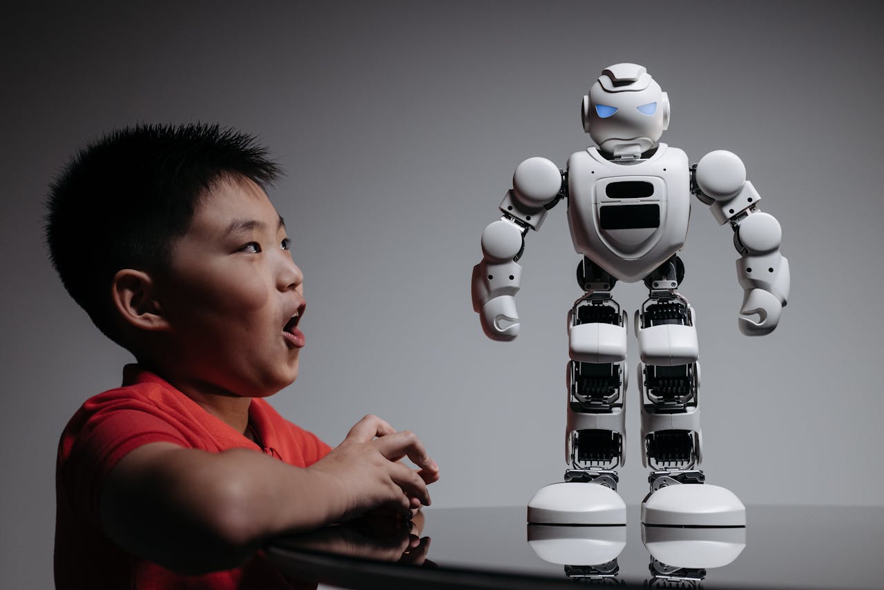 A young boy excitedly interacts with a white robotic toy, showcasing innovation and technology.